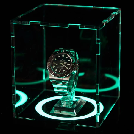 Teca per orologio con illuminazione ad anello LED settata sul verde in una stanza buia.
