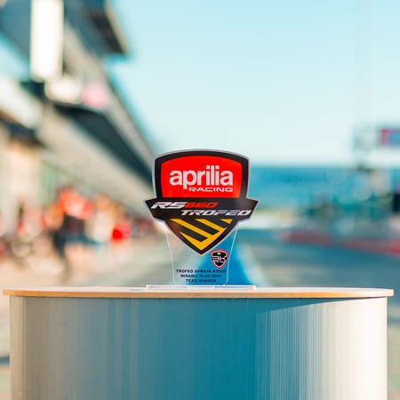 Trofeo personalizzato in plexiglass stampato con un grande scudetto rosso e nero riportante la scritta "Aprilia&quot